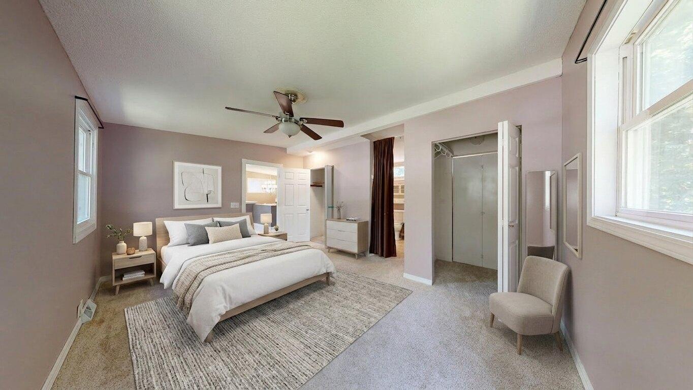 After virtual staging: empty bedroom staged with bed, nightstands, rug, chair, and dresser